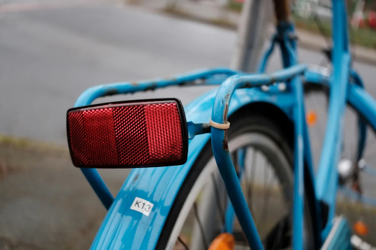 Närbild på röd reflex och bakljus monterat på cykel