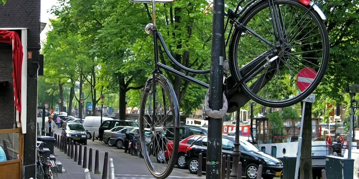 Cykellås av U-låstyp fastlåst runt cykelram och stolpe