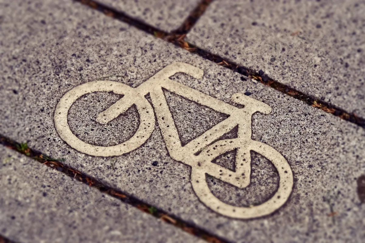 Cykelsymbol målad på marksten vid en svensk cykelväg