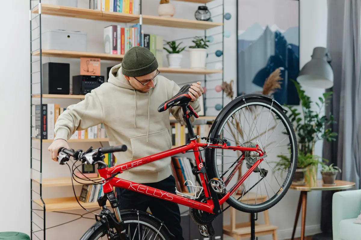 Person servar och lyfter sin cykel inomhus