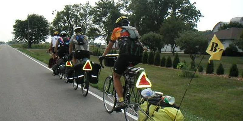 Grupp cykelturister med packväskor cyklar på landsväg