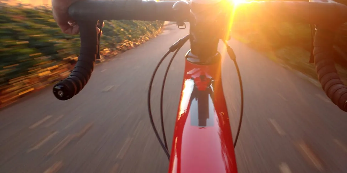Cyklist på landsväg i solnedgång med vackert landskap