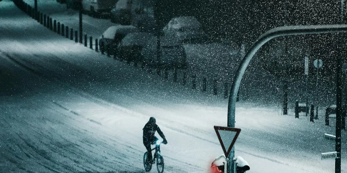 Cyklist på snötäckt väg i vinterlandskap