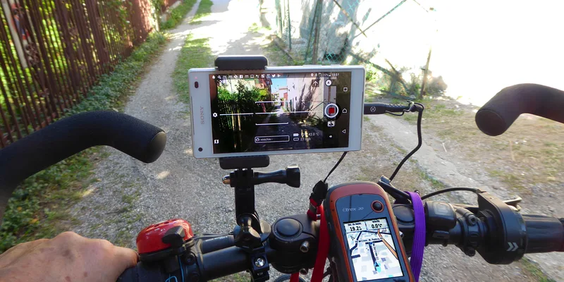 Smartphone och Garmin GPS monterade på cykelstyret med navigationskarta