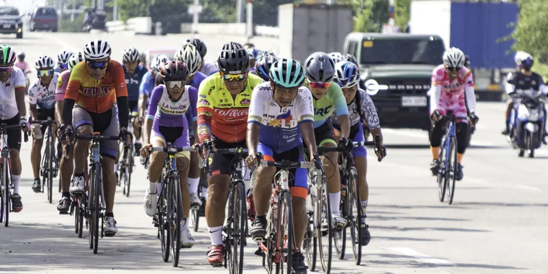 Cyklistpeloton under tävling med synliga knän och ben i tramprörelser